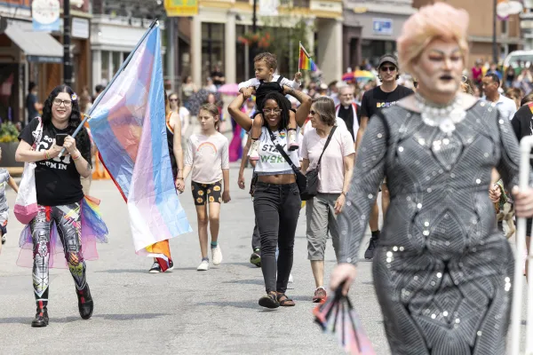 Pride parade full of happy people holding flags
