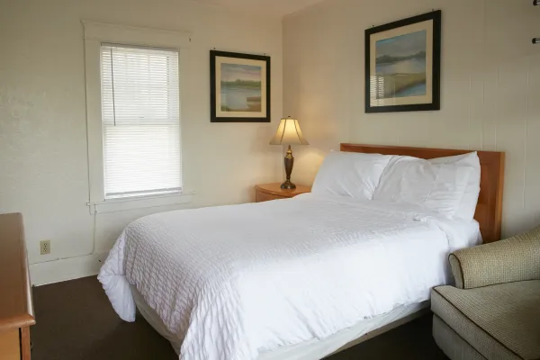 Plush white linens on a king bed in a bright room at The Ashley.