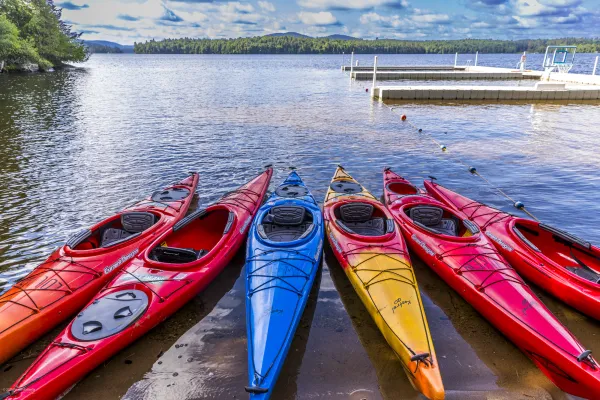 Brightly colored kayaks on the shore of the lake.