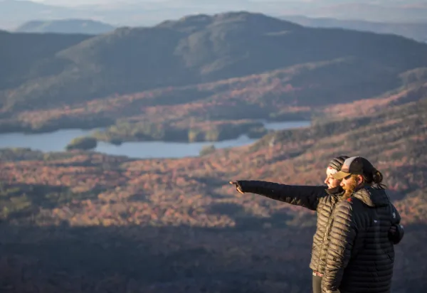 Hikers pointing at things from top of mountain
