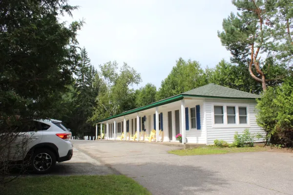 A white motel building with green roof.