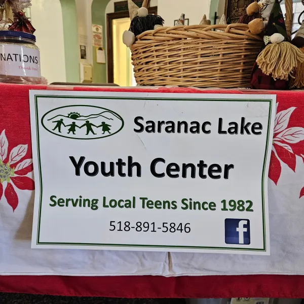 A table with a paper sign with Saranac Lake Youth Center