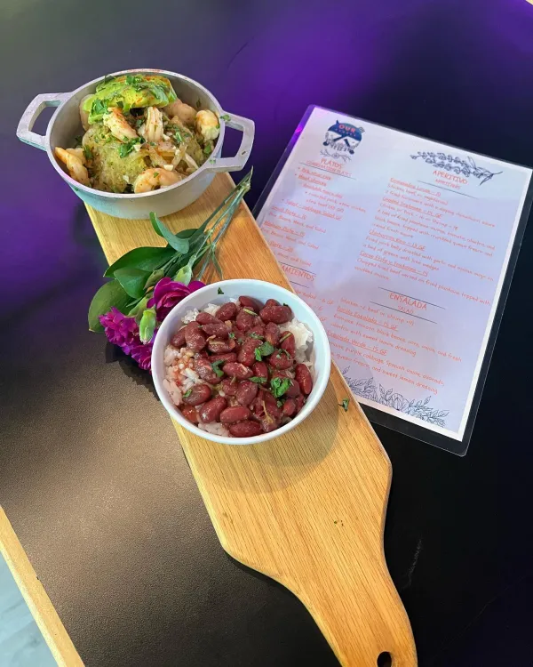 Two trial dishes set on a flight board with a menu from Our Plates