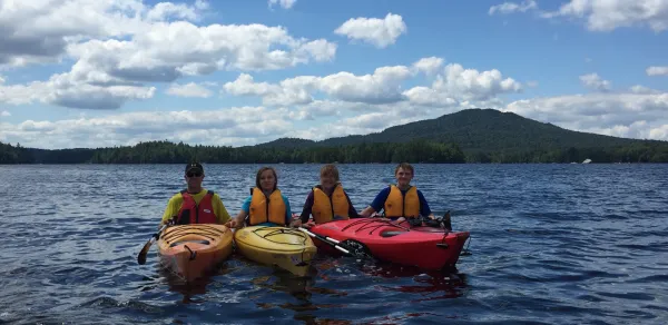 Kayakers stacked on the water to take a photo.