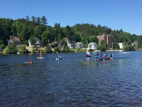 kids in handmade cardboard boats floating on lake flower
