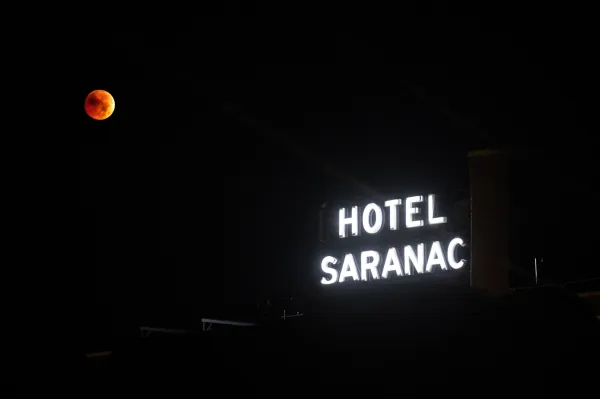 Hotel Saranac signage with a lunar eclipse pictured behind.
