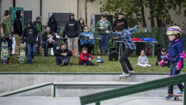 Young female is about to board in front of a crowd at the SL skate park