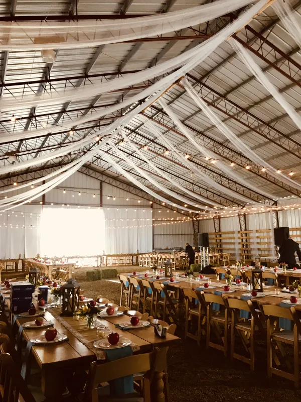 Tables set and toole garland hung from the ceiling in the barn.