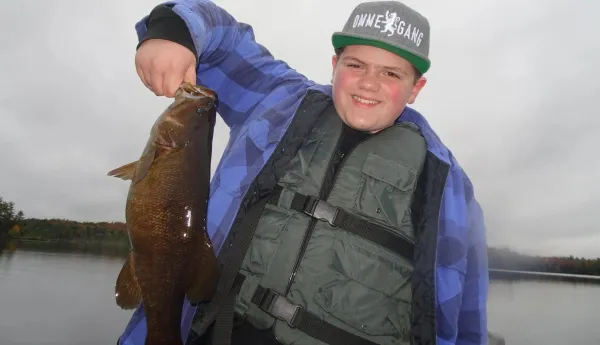 Happy young man holding a fish