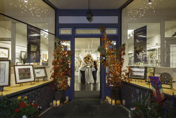 The entry way to NorthWind Fine Arts decorated for Fall with faux trees.