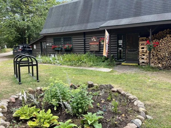 Exterior of the Floodwood Outpost with small garden and bike rack.