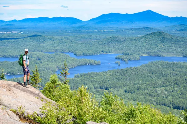 A man standing on the summit of St Regis Mountain
