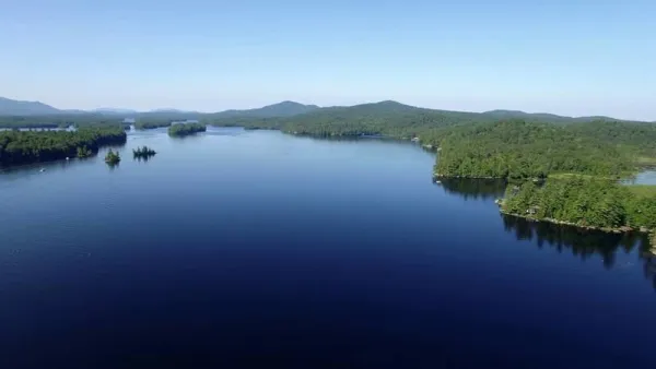 An aerial view of a lake with mountains in the background