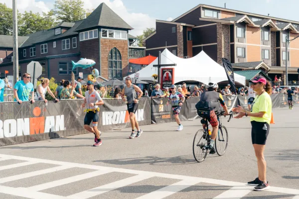 Ironman bikers and runners passing on the road