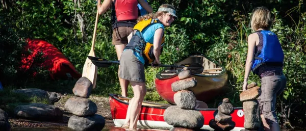 A smiling woman in a life jacket ready to board a boat.