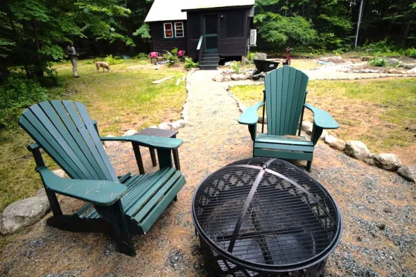 Outdoor fireplace and green adirondack chairs at Rockledge Cabins & Retreats 