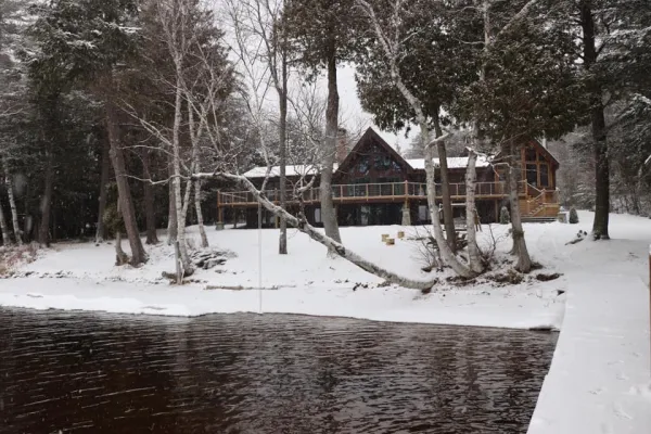 A winter scene at Alpenglow Lakeside Lodge showing the large lawn blanketed in snow.