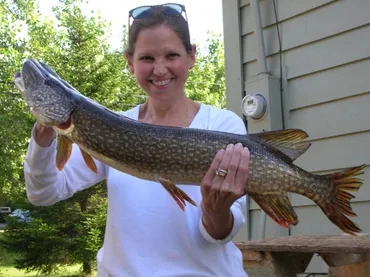 A smiling woman displaying her pike.