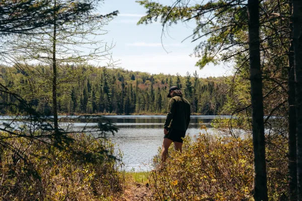 A hiker at a view of a small pond