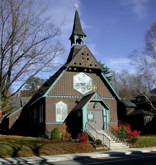 A small brown church with mint green trim.