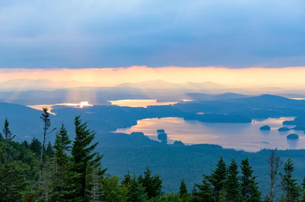 Stunning view of the reflection of the sunrise in a lake from the top of Ampersand Mountain