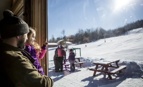 A dad holds his daughter inside the lodge at Pisgah