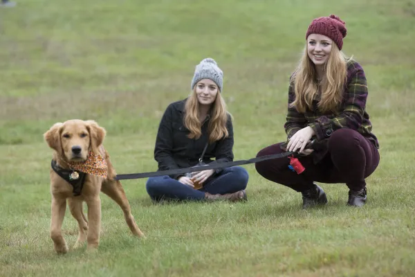 2 women with a golden puppy on leash