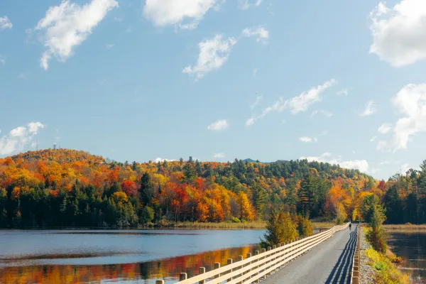 A causeway cuts through a lake in fall.