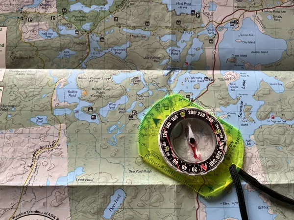 A map with a compass laying on top.