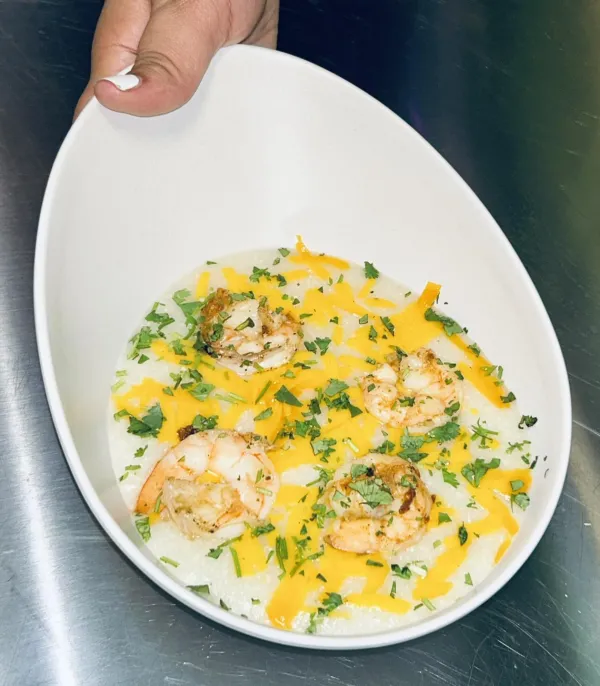 Camarones Y Grits at Our Plates - Creamy grits topped with seasoned shrimp, cheddar cheese and green onion.