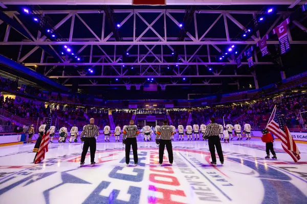 The image shows an indoor ice hockey arena filled with spectators. 