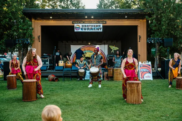A circle of drums extends out past the stage into the grass