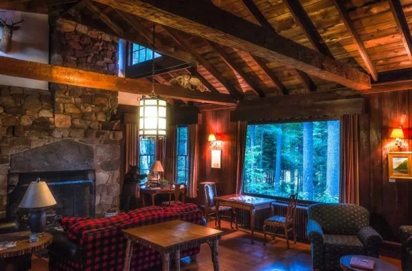 Rustic interior with high ceilings, rough beams and stone fireplace.