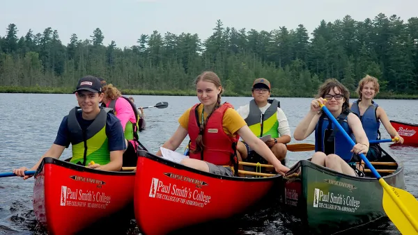 group of children in canoes on the water