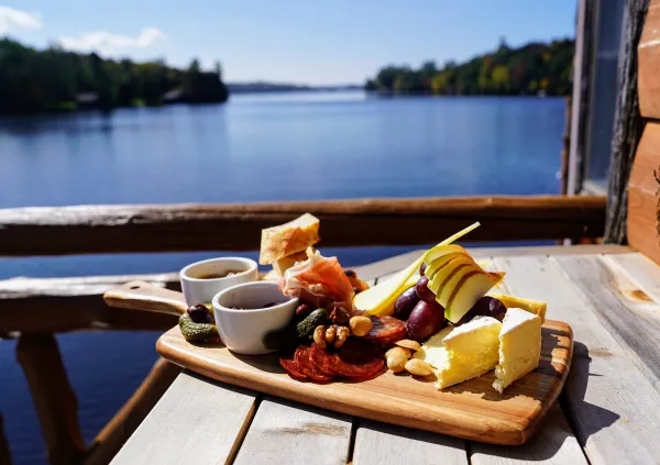 A cheeseboard on a plate, lakeside.