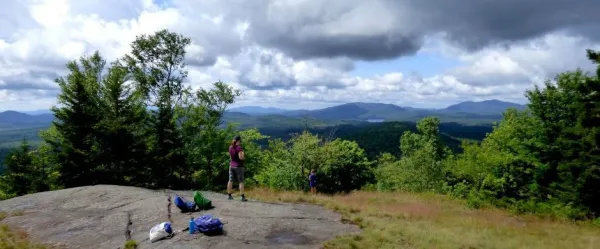 A hiker stands on partially open summit