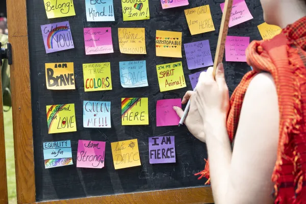 Sticky notes of affirmations hang on a chalkboard