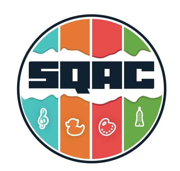 SQAC in badge striped  blue, orange, red and green with the symbols of a G cleft, rubber duck, artist pallet with clock tower
