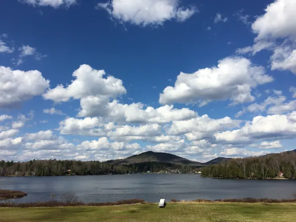 The puffiest white clouds over the lake and mountains.
