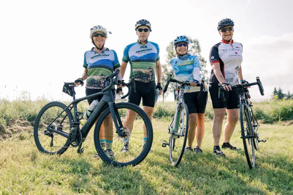 4 smiling people on bikes 