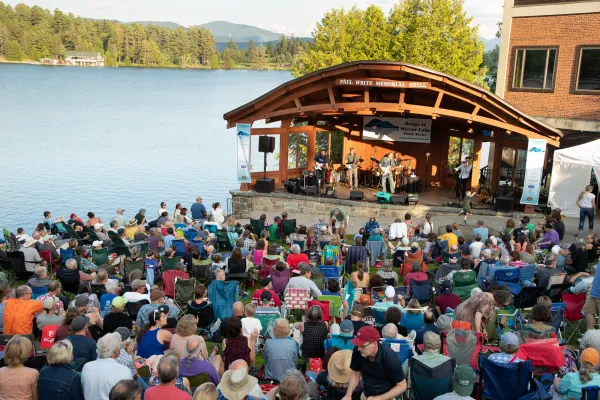 Crowd gathers in Mid's Park on a summer evening to listen to live music.