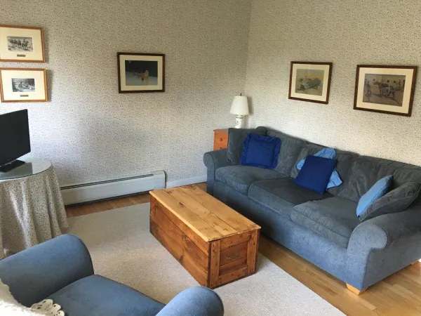 A living room with coffee table and blue couch and chairs.