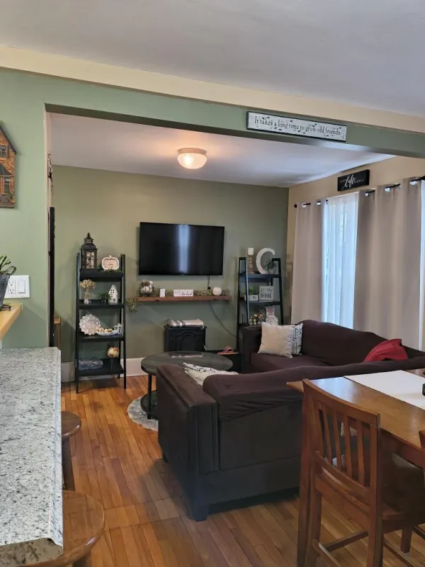 A green living room with wood floors and trim.