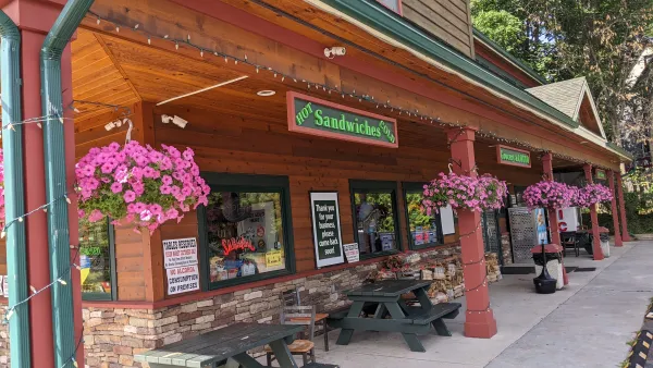 The covered porch with potted flowers in hanging baskets.