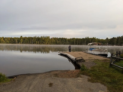 Sturdy boat launch onto a picturesque lake as smooth as glass and ringed with pines