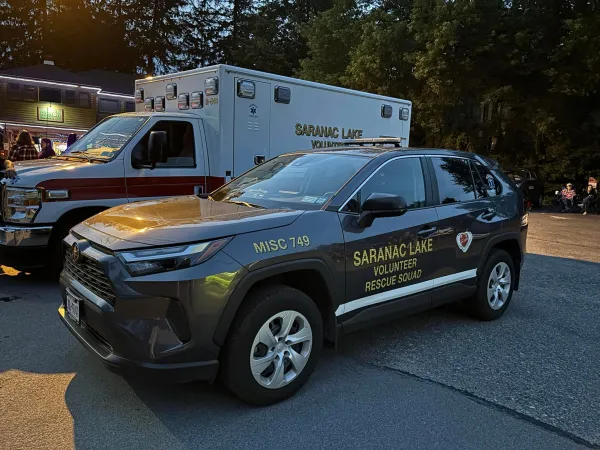 A car and ambulance labeled Saranac Lake Volunteer Rescue Squad.