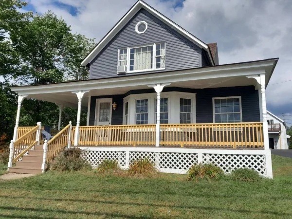 A blue house with white trim at the Sara Placid Inn & Suites.