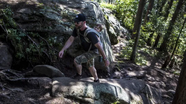 A man ascends a rocky part of the trail to the top of Baker Mountain