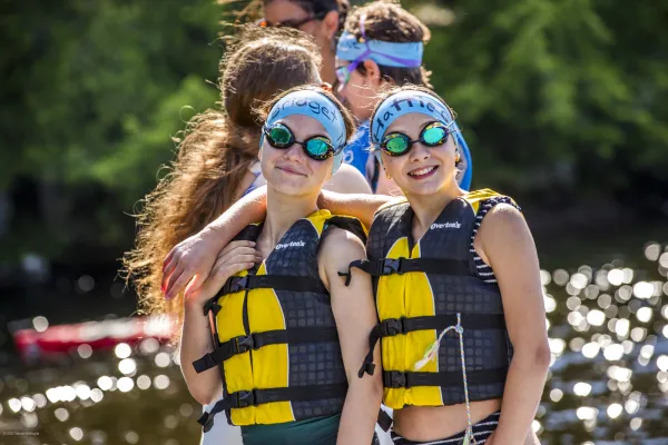 Smiling swimmers with their caps, goggles and life jackets.