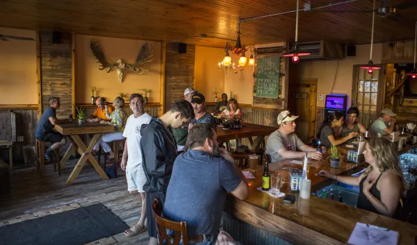 A view of the bar with lots of patrons.